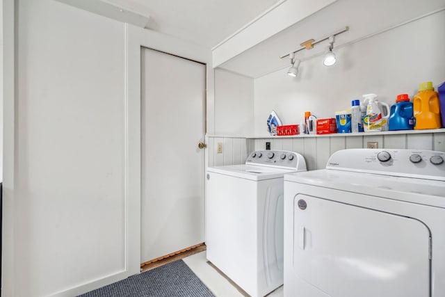 clothes washing area featuring track lighting and washer and clothes dryer