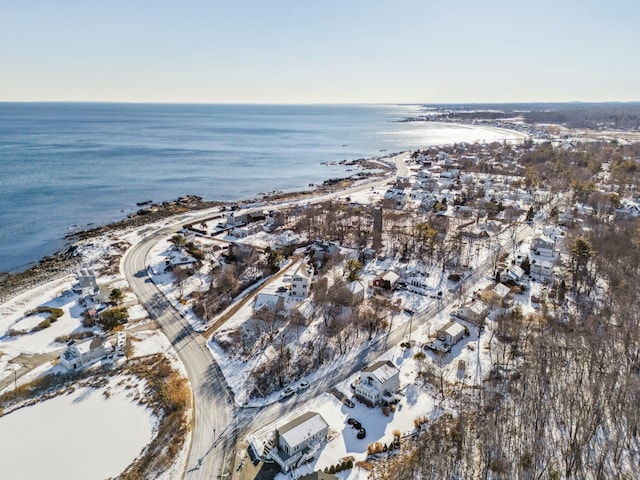 snowy aerial view featuring a water view and a view of the beach