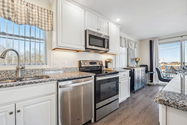 kitchen featuring white cabinetry, appliances with stainless steel finishes, sink, and light stone counters