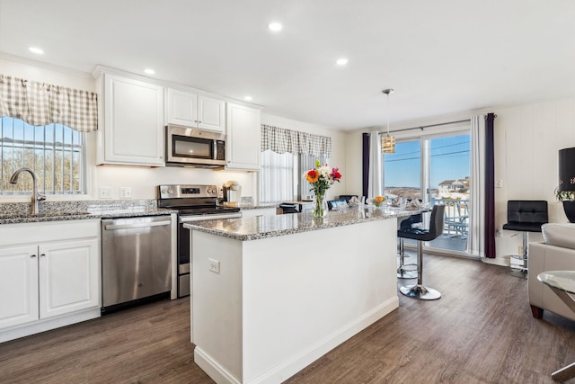 kitchen featuring sink, white cabinetry, a kitchen island, pendant lighting, and stainless steel appliances