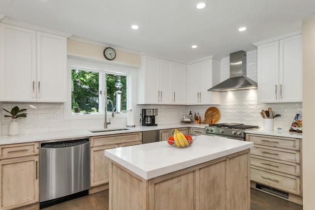 kitchen featuring wall chimney exhaust hood, sink, tasteful backsplash, a center island, and stainless steel appliances