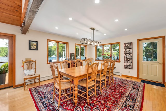 dining area with light hardwood / wood-style flooring, beamed ceiling, and a healthy amount of sunlight