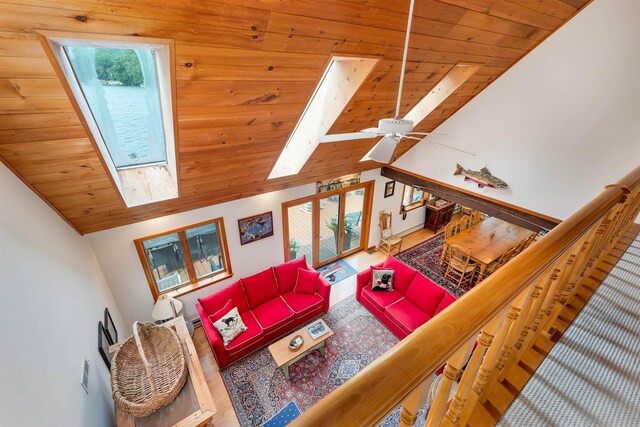 living room with wooden ceiling, high vaulted ceiling, and a skylight