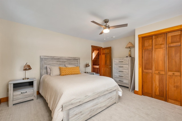 carpeted bedroom featuring ceiling fan and a closet