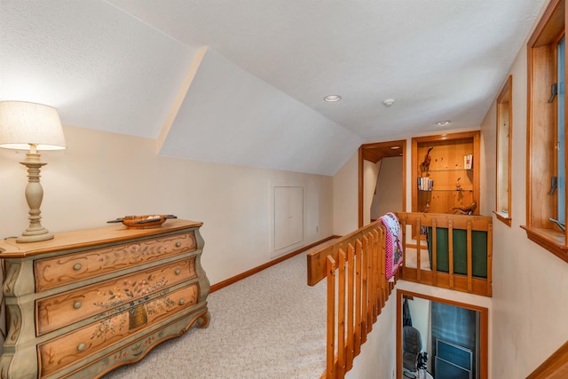 hall with light colored carpet and lofted ceiling