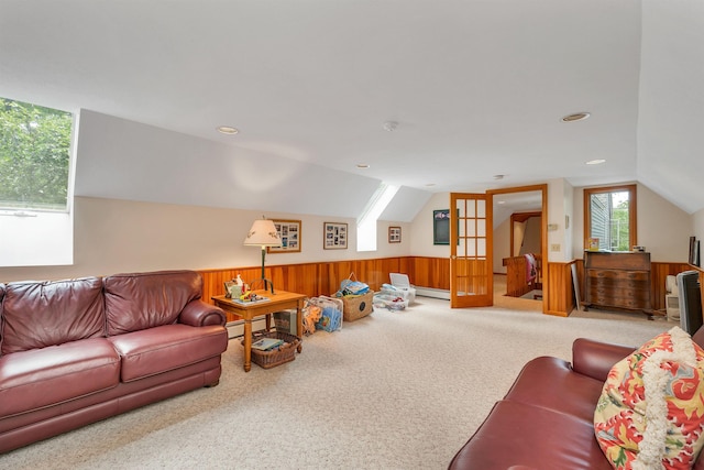 living room with lofted ceiling, carpet flooring, baseboard heating, and wood walls