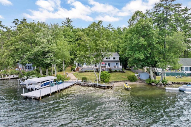 view of dock with a water view and a lawn