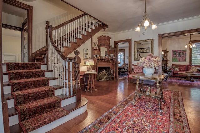 living room featuring ornamental molding, hardwood / wood-style floors, and a notable chandelier