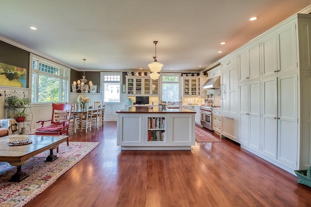 kitchen featuring butcher block counters, wood-type flooring, hanging light fixtures, double oven range, and a kitchen island