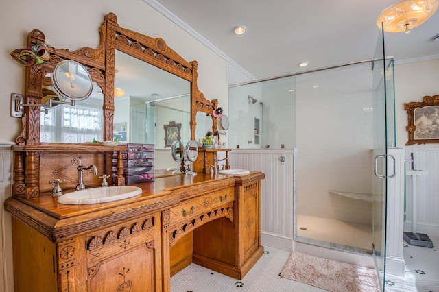 bathroom featuring ornamental molding, a shower with shower door, and vanity