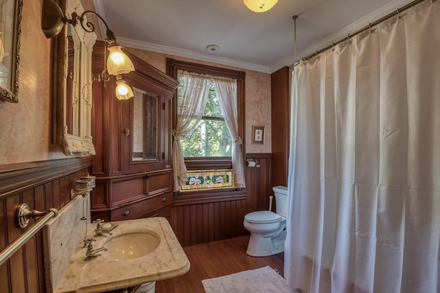 bathroom with sink, crown molding, wood-type flooring, and toilet