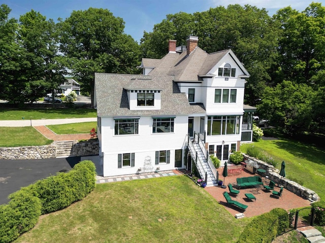 view of front of home featuring a front yard, a sunroom, outdoor lounge area, and a patio area