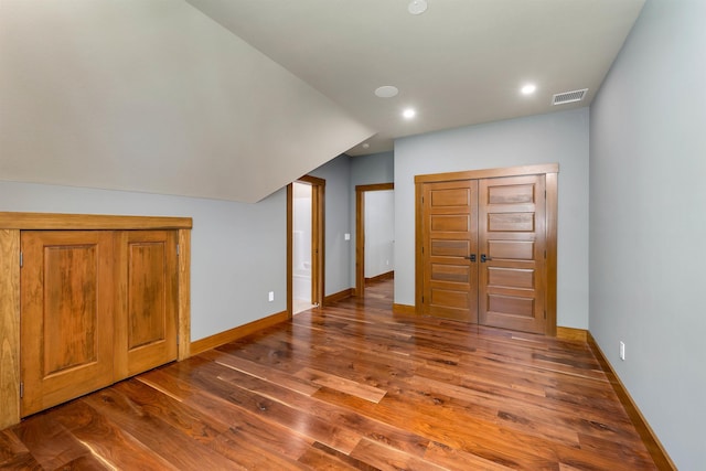 additional living space featuring hardwood / wood-style flooring and lofted ceiling