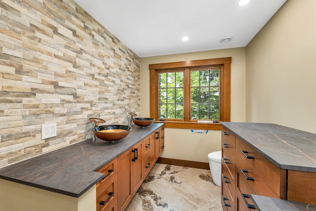 bathroom with vanity, toilet, and decorative backsplash