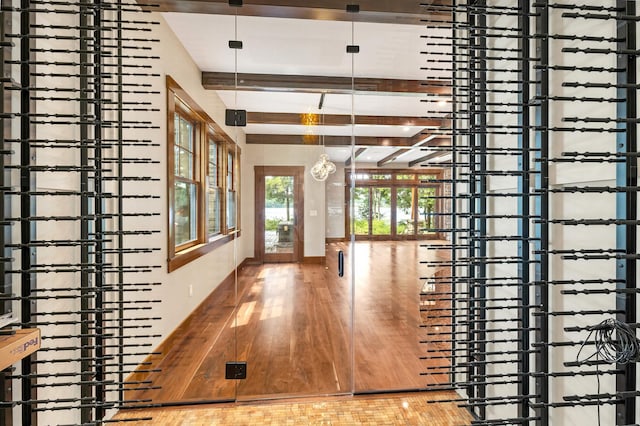 hallway with wood-type flooring and beamed ceiling