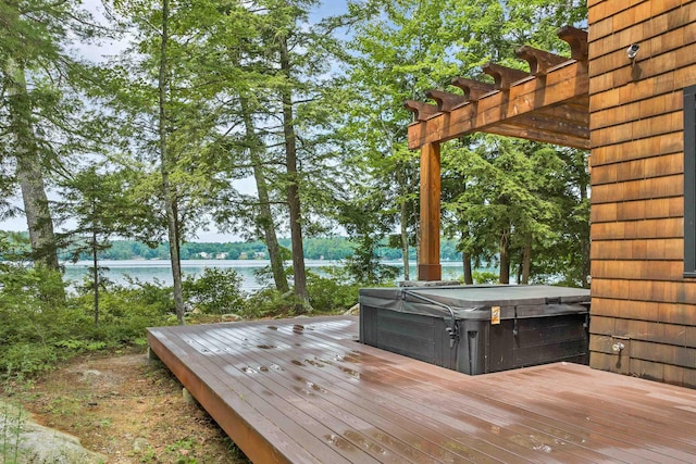 wooden terrace featuring a hot tub, a water view, and a pergola