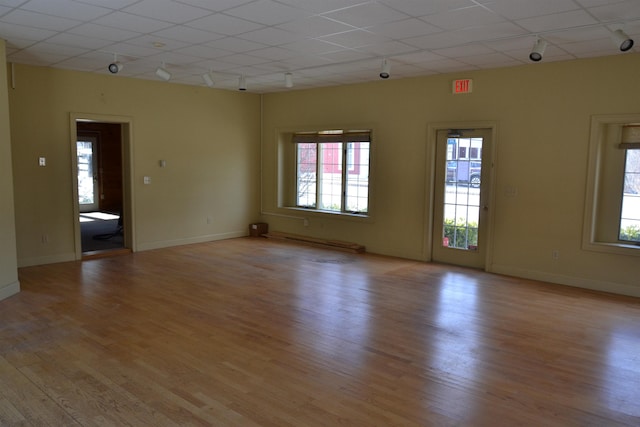 unfurnished room with light hardwood / wood-style flooring and rail lighting