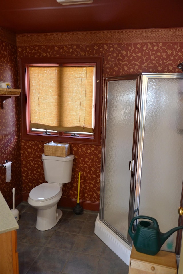 bathroom with tile patterned floors, a shower with door, and toilet