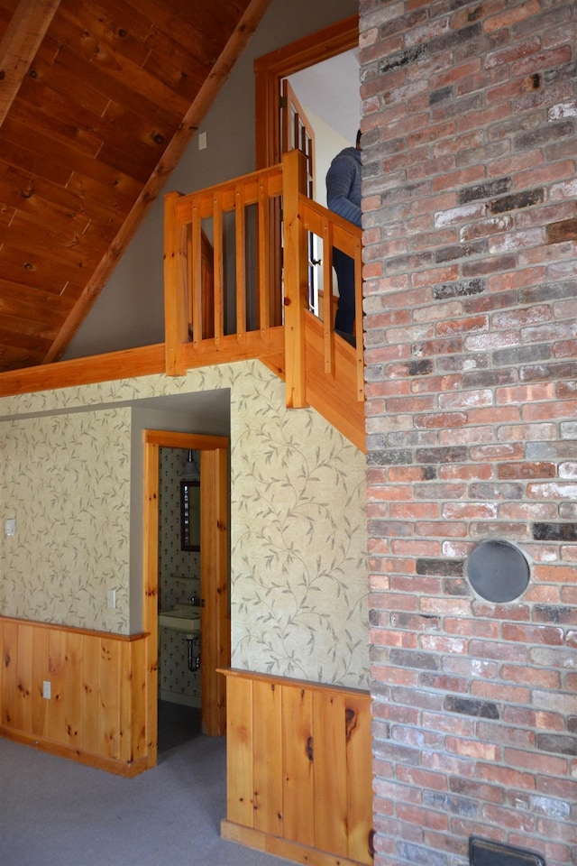 unfurnished living room featuring wood walls, carpet flooring, vaulted ceiling, and wooden ceiling