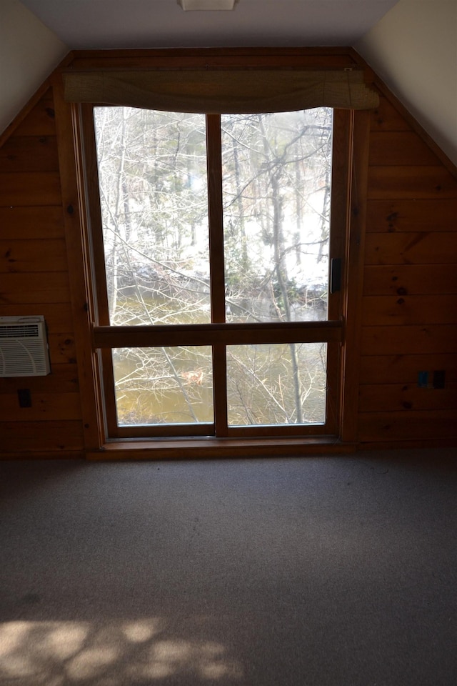 bonus room with lofted ceiling, an AC wall unit, and carpet flooring