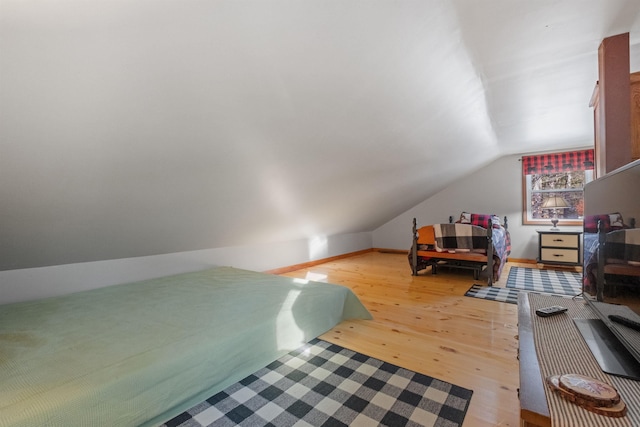 bedroom with hardwood / wood-style flooring and lofted ceiling