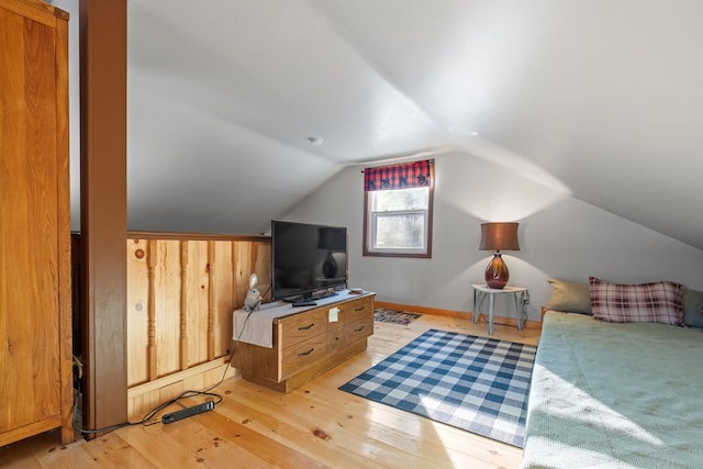 bedroom featuring vaulted ceiling and light wood-type flooring