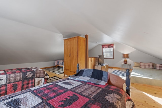 bedroom featuring hardwood / wood-style flooring and lofted ceiling