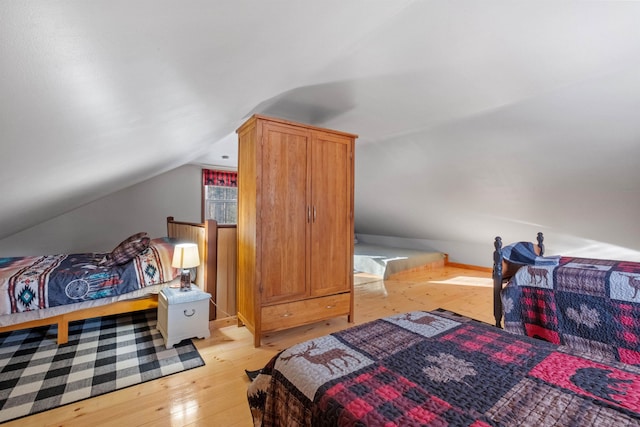 bedroom featuring vaulted ceiling and light hardwood / wood-style floors