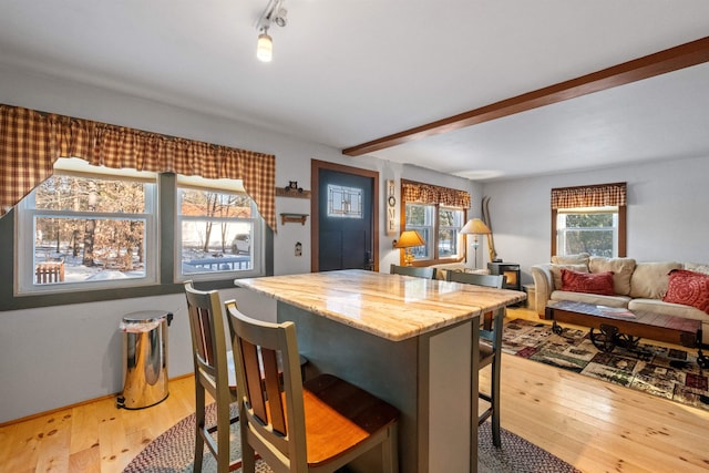 kitchen featuring hardwood / wood-style floors, beam ceiling, and a breakfast bar area