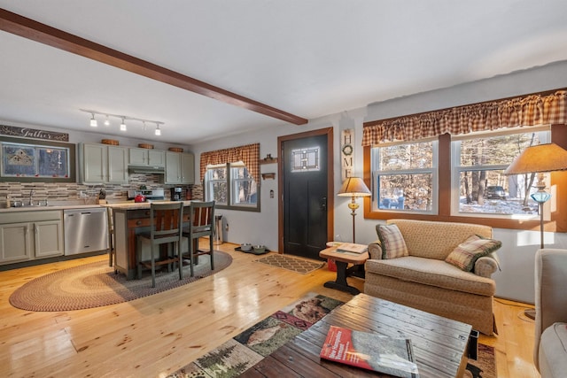 living room featuring beamed ceiling and light wood-type flooring