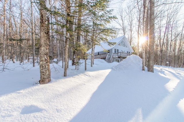 yard covered in snow featuring a deck