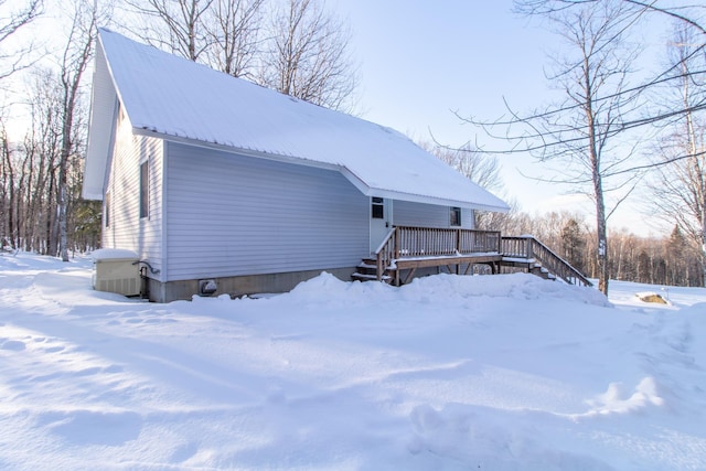 snow covered property with a deck