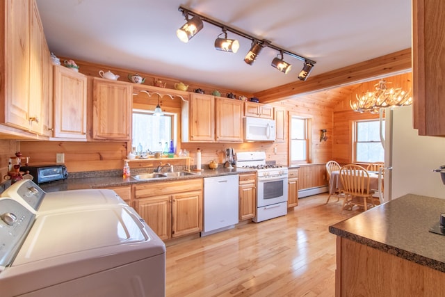 kitchen featuring sink, white appliances, hanging light fixtures, light brown cabinets, and independent washer and dryer