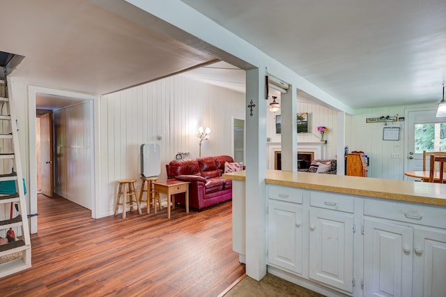 kitchen featuring decorative light fixtures, white cabinets, and hardwood / wood-style flooring