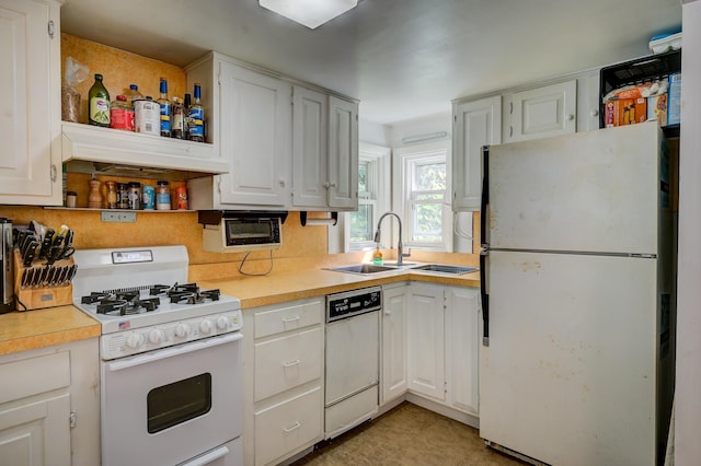 kitchen with white appliances, sink, and white cabinets