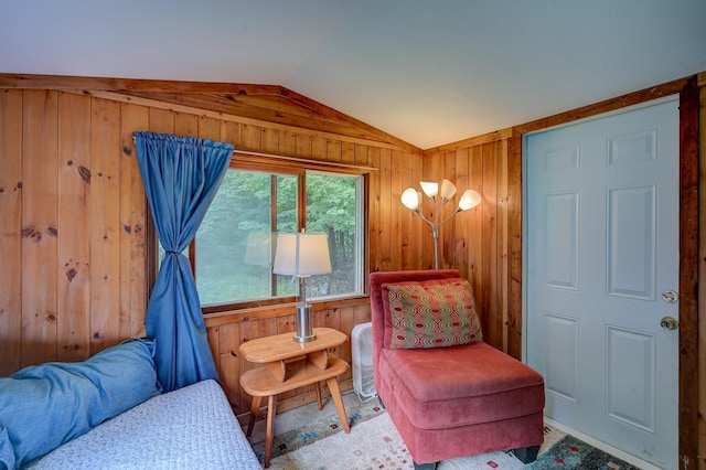 living area featuring lofted ceiling and wood walls