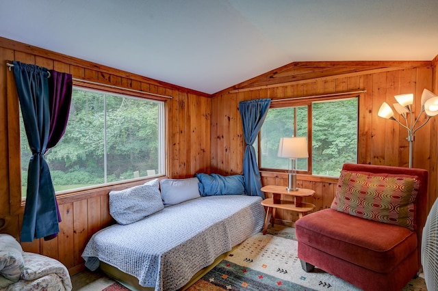 living area featuring vaulted ceiling and wood walls