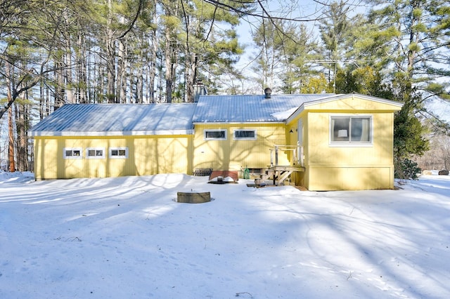 snow covered structure featuring a garage