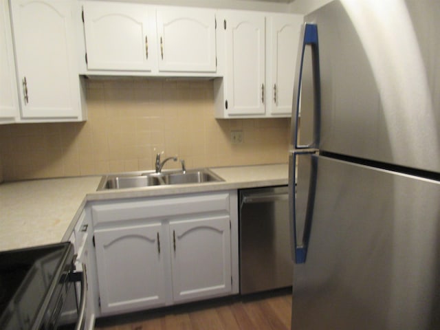 kitchen with sink, white cabinets, backsplash, stainless steel appliances, and dark wood-type flooring