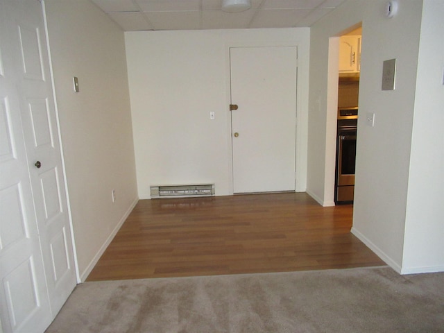 empty room with a drop ceiling and hardwood / wood-style floors