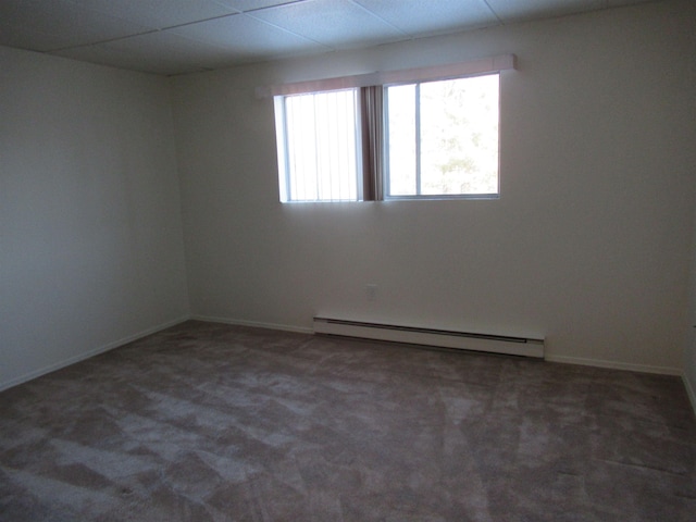 spare room featuring dark colored carpet and baseboard heating