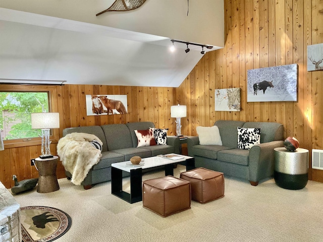 living room featuring wooden walls, vaulted ceiling, carpet, and rail lighting