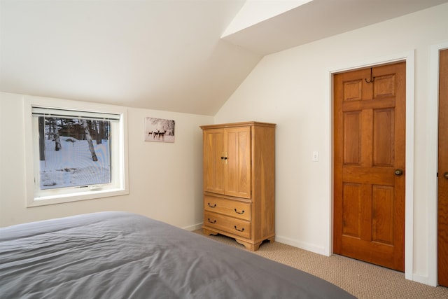 unfurnished bedroom featuring vaulted ceiling and light colored carpet