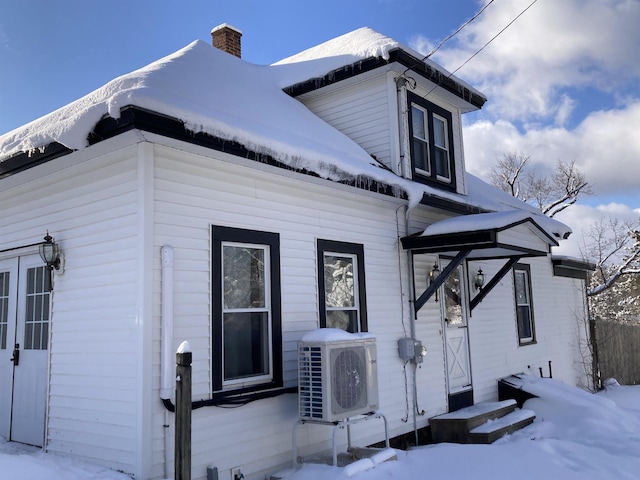 view of snowy exterior with ac unit