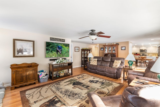 living room with ceiling fan and light hardwood / wood-style floors