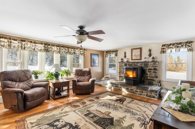 living room featuring hardwood / wood-style flooring, plenty of natural light, and a wood stove