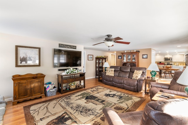 living room featuring ceiling fan and light wood-type flooring