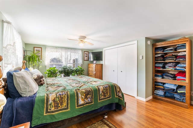 bedroom featuring ceiling fan, light hardwood / wood-style floors, and a closet