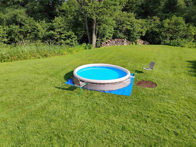 view of pool with a lawn