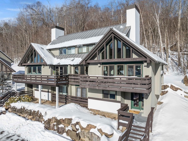 snow covered back of property featuring a deck